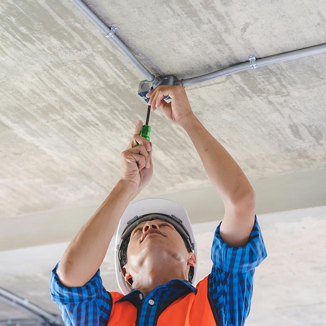 Licensed & insured electrician in Wisconsin Rapids installs ceiling wiring conduit with care.