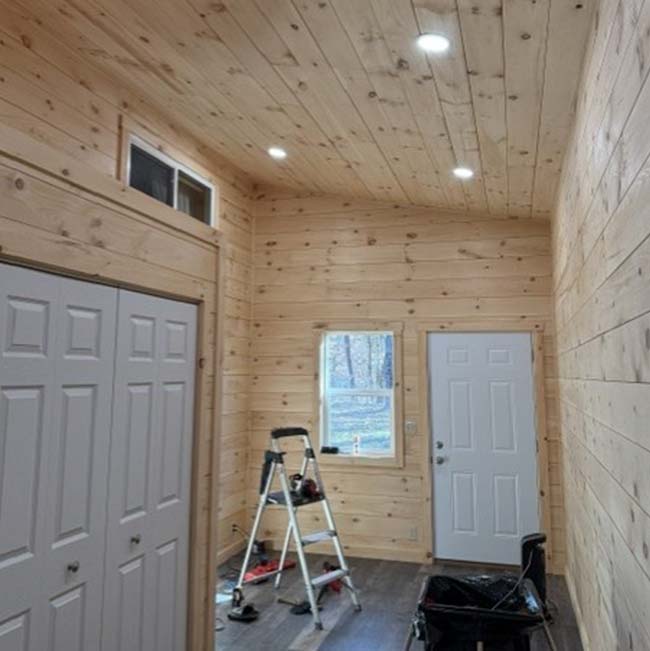 Wood-paneled room in Wisconsin Rapids with a ladder, open closet, window, and electrical fixtures.